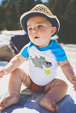 Full length shot of single baby boy sitting at beach