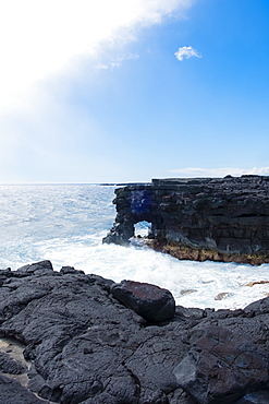 Coastal hiking scenic of the shore with waves crashing against the cliffs along the famed Puna Coast Trail to Halape Beach. The trail is 11.3 miles of rugged hiking for backpackers with no shade or water in the extreme terrain of Hawaii Volcanoes National Park, Hawaii, USA