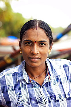 Head and shoulders portrait of mature woman with black hair looking at camera, Kerala, India