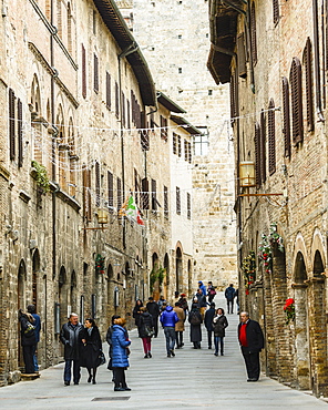 Tourists in San Gimignano, a small walled medieval hill town in the province of Siena, Tuscany, north-central Italy. Known as the Town of Fine Towers, San Gimignano is famous for its medieval architecture, unique in the preservation of about a dozen of its tower houses, which, with its hilltop setting and encircling walls