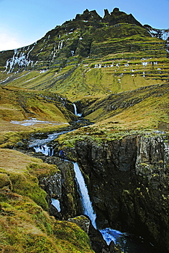 Beautiful natural scenery with waterfall and mountains below Oraefajokull glacier, Iceland