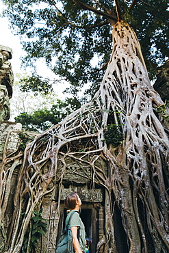 Waist up shot of woman looking at temple ruins, Siem Reap, Cambodia