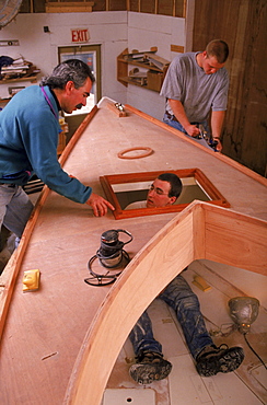 An instructor at the Landing School of boat building and Design instructs a student while building a boat.