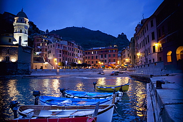 Boats Moored By Buildings Along The Waterfront At Night; Vernazza Liguria Italy
