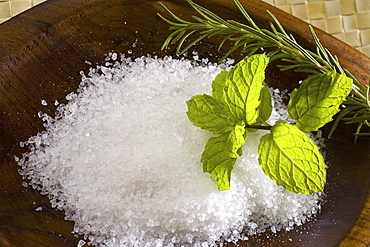 Spa elements, koa bowl filled with raw salt, garnished with a sprig of mint and rosemary.