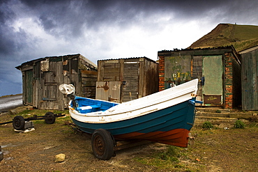 Boat Beside Old Shacks