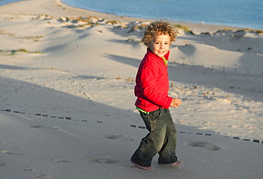 A Boy Walking In The Sand