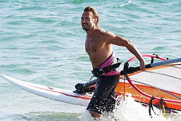 A Man Comes Walks In The Water With His Windsurfing Equipment, Tarifa, Cadiz, Andalusia, Spain