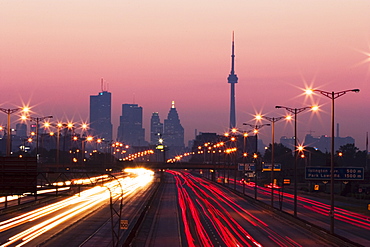 View Of Toronto Skyline From Above Queen Elizabeth Way Highway During Start Of Rush Hour Traffic, Toronto, Ontario, Canada.