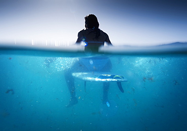 A Woman Sitting On A Surfboard In The Water, Tarifa, Cadiz, Andalusia, Spain