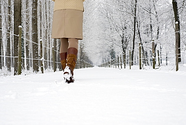 A woman walks down a snowy path in winter, Locarno ticino switzerland