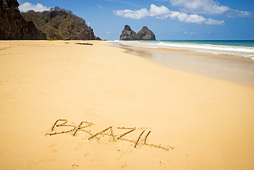 View of morro dos irmaos from praia do bode with brazil written in the sand, Fernando de noronha pernambuco brazil