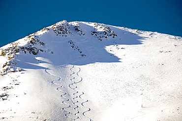 Snow covered mountain peak with skier tracks and deep blue sky, Lake louise alberta canada