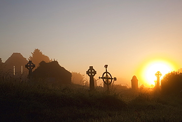 Sunrise at aghadoe heights graveyard with silhouetted tombstones, Killarney, county kerry, ireland