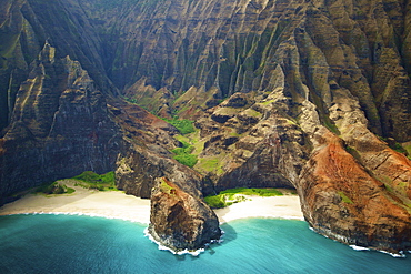 Blue water and white sand in a small inlet along a rugged coastline, Hawaii united states of america