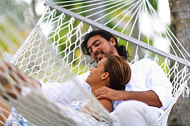 A man and woman in a hammock at the bora bora nui resort and spa, Bora bora island society islands french polynesia south pacific