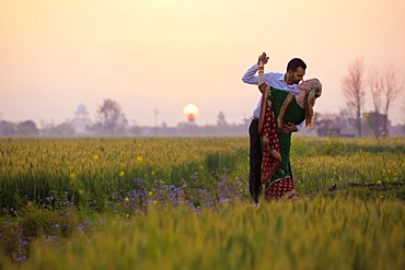 Portrait Of A Mixed Race Couple Her Wearing A Sari In A Field At Sunset, Ludhiana, Punjab, India