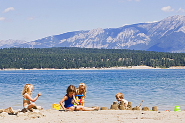 Children Playing On Beach On Lake Koocanusa In The East Kootenays Near Fernie, British Columbia, Canada