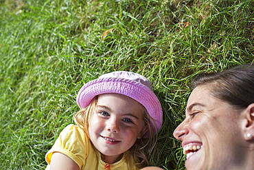 Young Girl Laying On The Grass With Her Mother Laughing, Toronto, Ontario, Canada