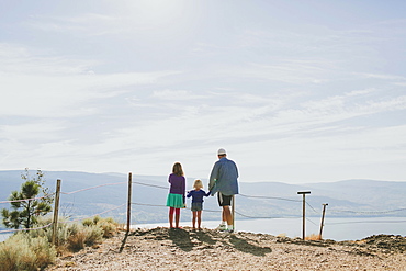 A Family Stands Together Overlooking A View Of Lake Okanagan, Peachland, British Columbia, Canada