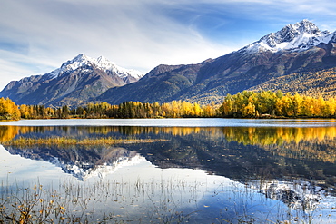 The Snowcapped Chugach Mountains And Autumn Foliage Reflecting In Reflections Lake Along The Glenn Highway In The Matanuska Susitna Valley, Alaska, United States Of America