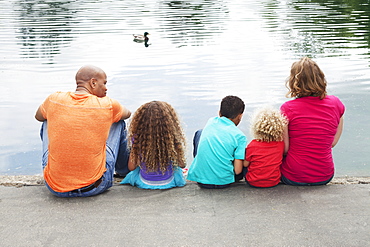 Family Of Five Sitting On The Edge Of A Pond, Menlo Park, California, United States Of America