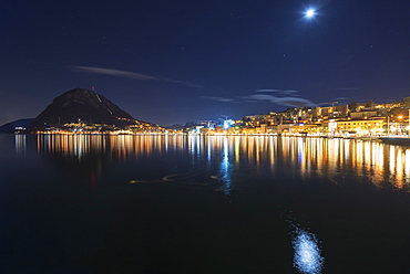 City Lights Illuminated On The Tranquil Lake Lugano, Lugano, Ticino, Switzerland