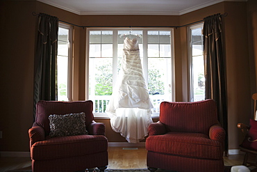 A Wedding Dress Hanging In The Window Of A Home, British Columbia, Canada