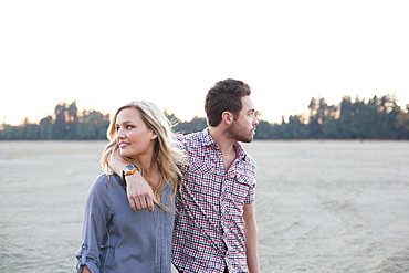 A Couple Walking In An Embrace Along The Water's Edge, Victoria, British Columbia, Canada