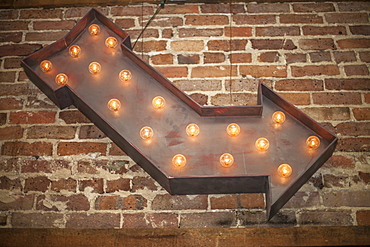 Lighted Metal Arrow Sign On Brick Wall, Starkville, Mississippi, United States Of America