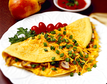 Food - Cheese and Mushroom Omelette garnished with chopped green onions (scallions) and pear tomatoes.