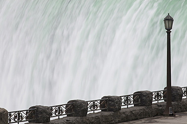 Railing And Lamp Post With The Horseshoe Falls In The Background At Table Rock, Niagara Falls, Ontario, Canada