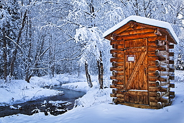 Log Outhouse By A Meandering Creek In Snow, Chena Hot Springs Resort, Fairbanks, Alaska, United States Of America