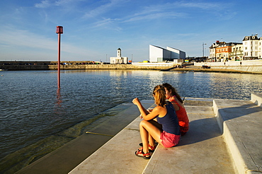 Teenage Girls Sitting On Steps Along The Waterfront, Margate, Kent, England