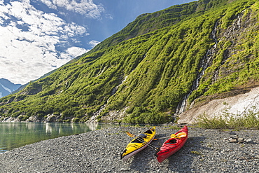 Two Kayaks On The Beach In Front Of Green Mountain With Waterfall At Shoup Bay State Marine Park, Prince William Sound, Valdez, Alaska, United States Of America