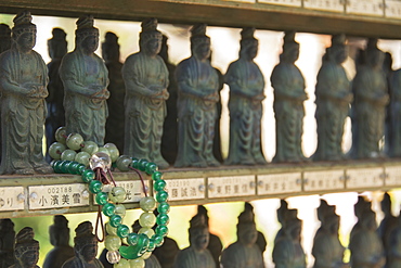 Buddhist Bracelet Wrapped Around A Temple Figurine Among Many, Ohara, Kyoto, Japan