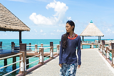 A Young Woman Walks On The Pier At Independence Beach, Sihanoukville, Cambodia