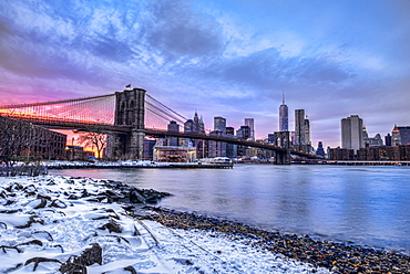 Brooklyn Bridge With Snow-Covered Landscape At Sunset, Brooklyn Bridge Park, Brooklyn, New York, United States Of America