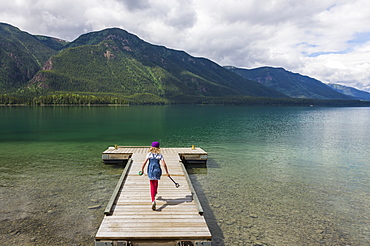 Young Girl On A Dock At Muncho Lake Provincial Park, British Columbia, Canada, Summer