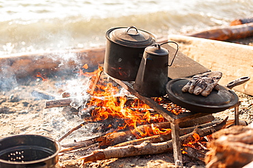 Close Up Of Coffee Pot And Cast Iron Dishes Over A Campfire, Yukon Territory, Canada