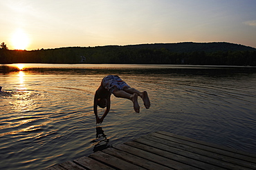 Boy Diving Into A Lake At Sunset, Lac Des Neiges, Quebec, Canada