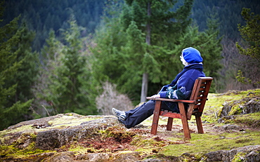 Woman Sitting In A Chair Looking At Nature, Bowen Island, British Columbia, Canada