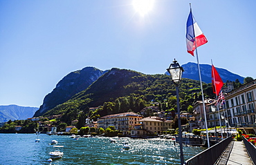 Sunshine On The Italian Flag And Waterfront Views From The Town Of Menaggio On Lake Como, Menaggio, Lombardy, Italy