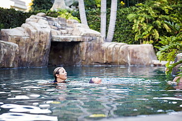 A Family Enjoys An Afternoon In The Pool On A Sunny Afternoon, Fountain Valley, California, United States Of America