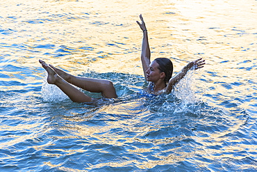 A Young Woman In The Water With Her Torso Immersed And Her Arms And Legs Above The Water, Exercising, Tarifa, Cadiz, Andalusia, Spain