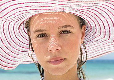 Portrait Of A Young Woman Wearing A Red And White Striped Sunhat, Tarifa, Cadiz, Andalusia, Spain