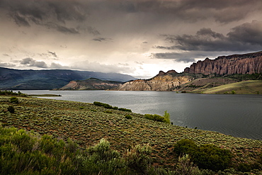 The Water And Rock Cliffs Of Blue Mesa Reservoir With Moody Clouds And Interesting Light, Gunnison, Colorado, United States Of America