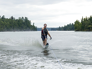 A Man Wake Boarding On A Lake, Ontario, Canada