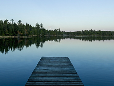 Wooden Dock Leading Out To A Tranquil Lake At Sunrise, Whiteshell, Manitoba, Canada