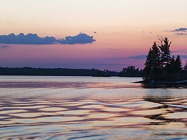 Lake Of The Woods At Sunrise With The Pink Sky Reflected In The Tranquil Water, Ontario, Canada